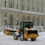 yellow and black heavy equipment on snow covered ground near building